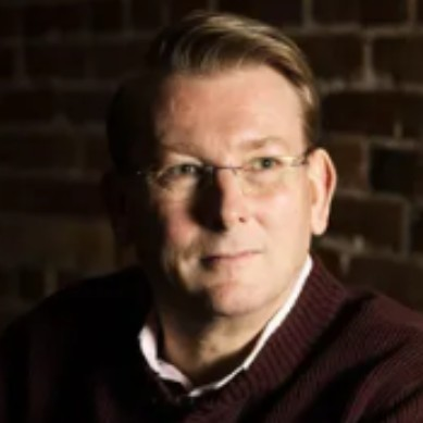 Kaj_Pedersen CTO of AstrumU seen in a white color shirt and a drak brown color cote over it